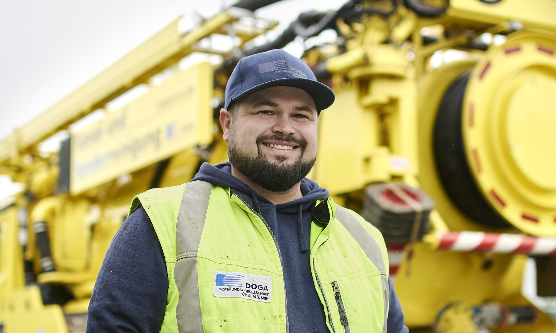 Ein freundlich lächenlder DOGA Mitarbeiter vor einem großen Fahrzeug